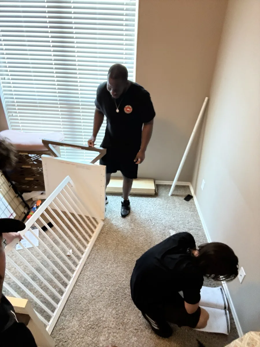 Red Dirt Moving crew assembling furniture at a customer's new home