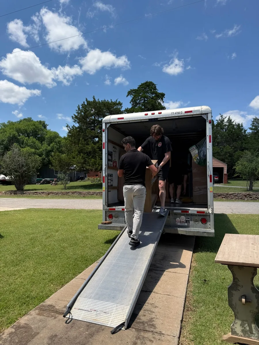 Red Dirt Moving crew loading furniture up the ramp into a moving truck