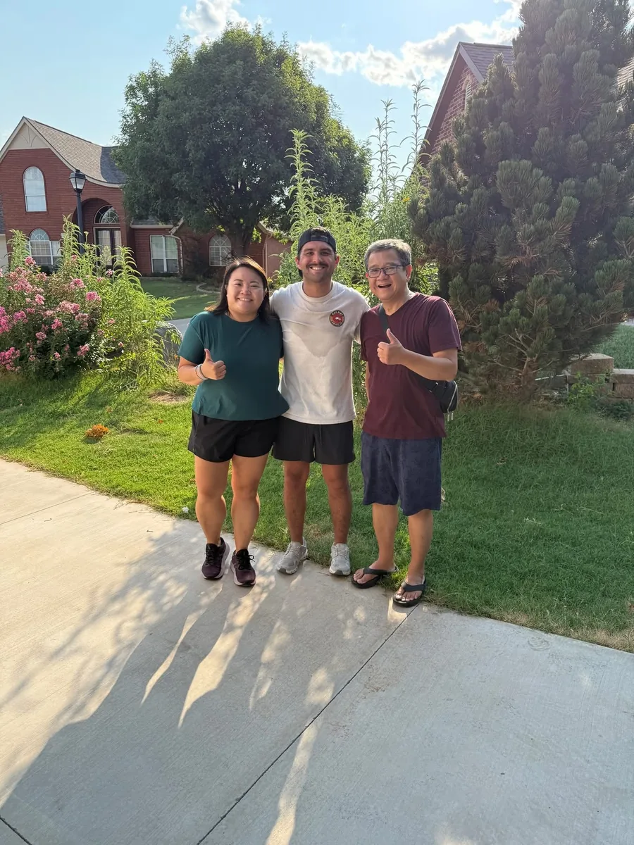 Red Dirt Moving Co. owner with happy customers outside their Norman home